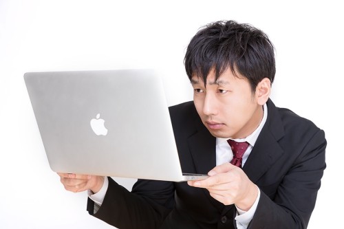 パソコンを読む男性